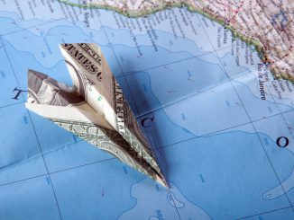 Paper plance on travel map symbolizing and expensive journey
